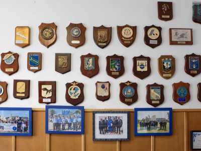 Diamo un�occhiata in giro. Su una parete sono affissi decine di crest, scudi araldici in legno e metallo che rappresentano un reparto o una missione specifica dell�Aeronautica Militare
